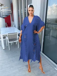Full-length view of a blue handmade knitted hollow-out maxi dress with elegant fringe details
