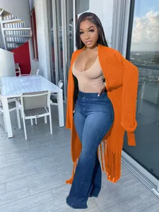 Detailed view of women's orange chunky knit long cardigan sweater with long fringe trim