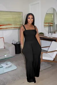 Detail view of a black wide-leg jumpsuit featuring smocked bodice and side pockets