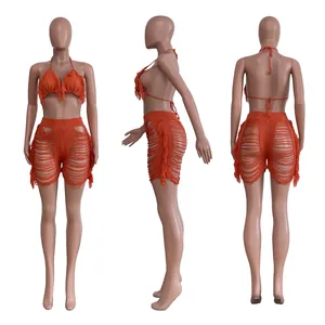 Detailansicht eines orangefarbenen Häkel-Bikini-Sets mit Fransen und passenden Shorts.