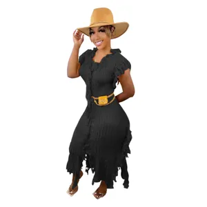 Woman wearing a black knitted sleeveless dress with tassel details and a straw hat.