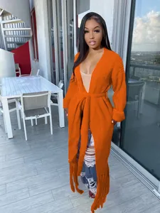 Long orange knit cardigan featuring a tie-waist and elegant fringe hem decoration