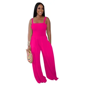Full length view of a fuchsia smocked bodice wide-leg jumpsuit with straps and clutch