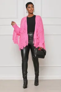 Detailed view of a fashionable pink knitted cardigan with fringe details worn by a model