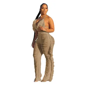 Vue latérale d'une femme en bikini kaki et pantalon de plage en maille à franges