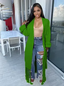 Long green fringed cardigan sweater coat for women in an outdoor balcony setting