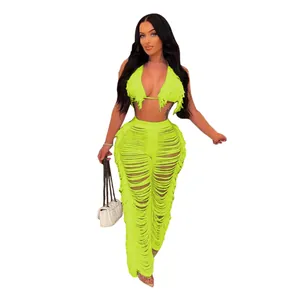 Modèle portant un haut de bikini à franges vert fluo et un pantalon de plage assorti