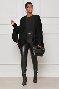 Close-up of black fringed knit cardigan jacket featuring long tassel sleeve details.