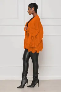 Close-up detail of a bright orange solid knit cardigan featuring heavy fringe trim.