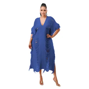 Close-up of handmade blue knit dress with elegant tassel details and hollow-out design