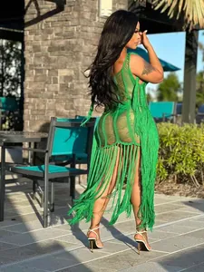 Vue arrière d'une robe de plage sexy en crochet vert avec des franges évidées au soleil.
