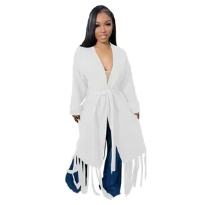 Full view of a women's long white knit cardigan featuring fringe hem and a tie waist