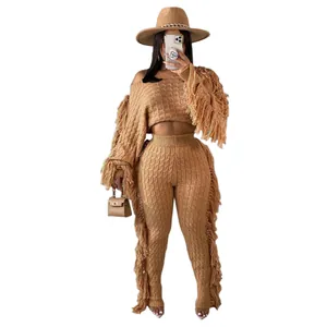 Close-up of women's camel knit two-piece set with long sleeves and tassel fringe