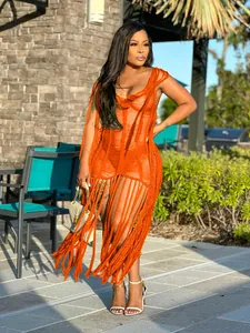 Femme portant une robe de plage orange sexy crochetée à la main avec des franges