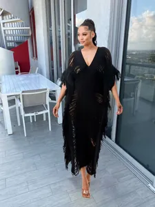 Elegant handmade black knit long dress with transparent fringe details shown on a model.