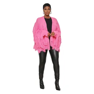 Close-up of a vibrant pink knitted cardigan with oversized fringe detailing on a model.