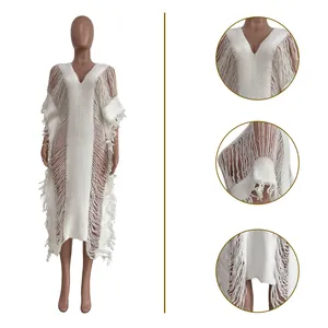 Macro view of white handmade knitted see-through long dress with elegant fringe details.