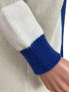 Close-up view of the blue ribbed cuff and high-quality knit texture on a color-block sweater