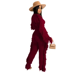 Detailed view of burgundy knit long-sleeve top and pants set featuring long fringe trim.