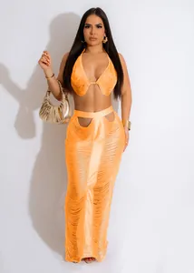 Dettaglio di un set arancione con nappe, top con frange e gonna lunga coordinata