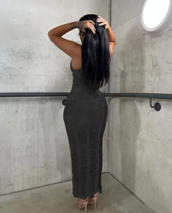 Back view of a black knit hollow-out maxi beach dress on a model in industrial setting