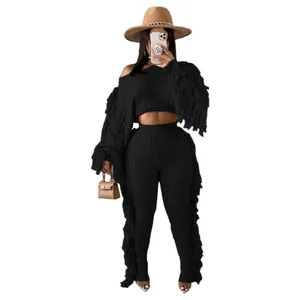 Detailed view of women's black cable knit two-piece set featuring stylish long fringe trim