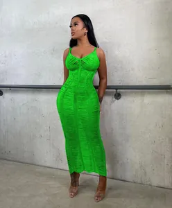 Neon green knitted cutout maxi beach dress shown on a model against a concrete wall