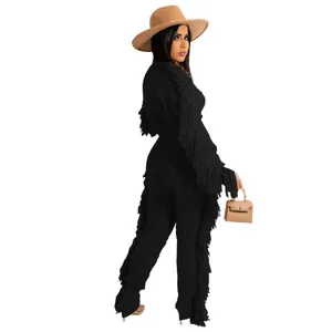 Side view of black knitted two-piece set with stylish fringe details on sleeves and pants legs.