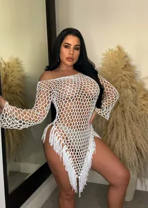 Detailed view of hand-knitted fishnet beach dress with white tassels and mesh.