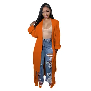 Detailed view of women's long orange knitted cardigan sweater with stylish fringe hemline