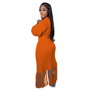Detailed side view of long orange knit cardigan featuring stylish tassel fringe hem