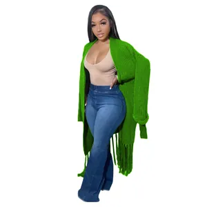 Full-length view of a vibrant green long-sleeved tassel cardigan on a fashion model.
