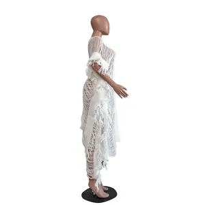 Close-up detail of white hand-knitted hollow-out dress with fringe trim and texture