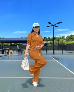Vue détaillée d'un ensemble deux pièces en maille orange avec col polo et pantalon large.