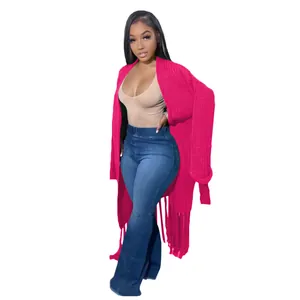 Full view of long bright pink knit cardigan featuring elegant fringe hem details