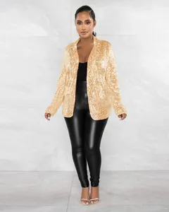 Détail d'un blazer à paillettes dorées pour femmes avec pantalon en similicuir.