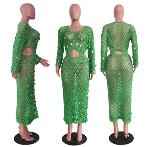Dettagli di un abito lungo all'uncinetto verde con paillettes e maglia traforata fatta a mano