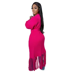 Elegant side view of a long hot pink knitted cardigan featuring a stylish long fringe hem
