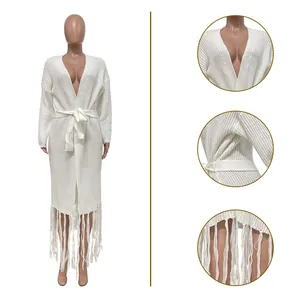 Detail view of white long cardigan featuring knitted texture, tassel hem, and waist tie.