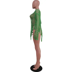 Detailed side profile of sexy green hand-knitted large mesh beach dress with tassels