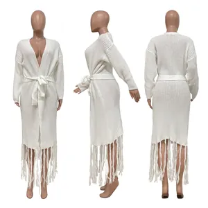 Detailed view of a long white knit cardigan featuring a waist belt and stylish fringe tassels.