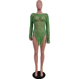 Macro view of handmade green crochet mesh beach cover-up with decorative tassels
