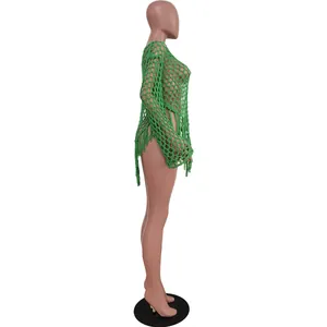 Detailed side view of a sexy green hand-knitted wide mesh beach dress with fringe