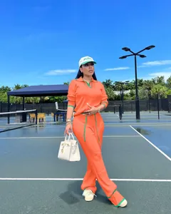 Détail de l'ensemble deux pièces en tricot orange avec une bordure verte élégante