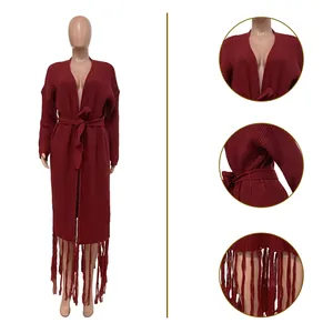 Detail view of a long burgundy knit cardigan featuring a fringe hem and waist tie closure