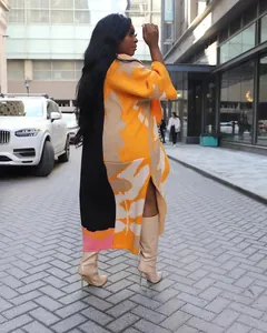 Seitenansicht der langen Strickjacke mit abstraktem orange-schwarzem Colorblock-Muster