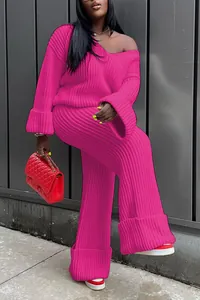 Detailed view of the vibrant pink knitted two-piece set featuring a V-neck sweater and pants
