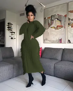 Detailed view of dark olive green cable-knit maxi dress with decorative side fringes.
