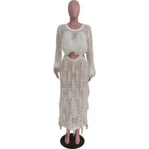 Full view of white crochet hollow-out maxi beach dress with elegant fringe detailing.