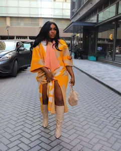 Komplette Lifestyle-Ansicht eines schicken orange-beigen Strick-Cardigans an einem Model draußen